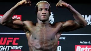 Losene Keita poses on the scale during the UFC Paris official weigh-ins