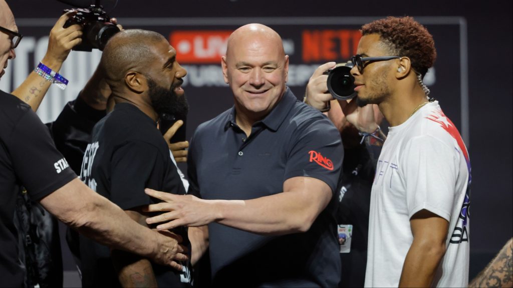 Dana White separates two fighters after a faceoff during a press conference