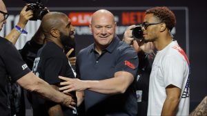 Dana White separates two fighters after a faceoff during a press conference