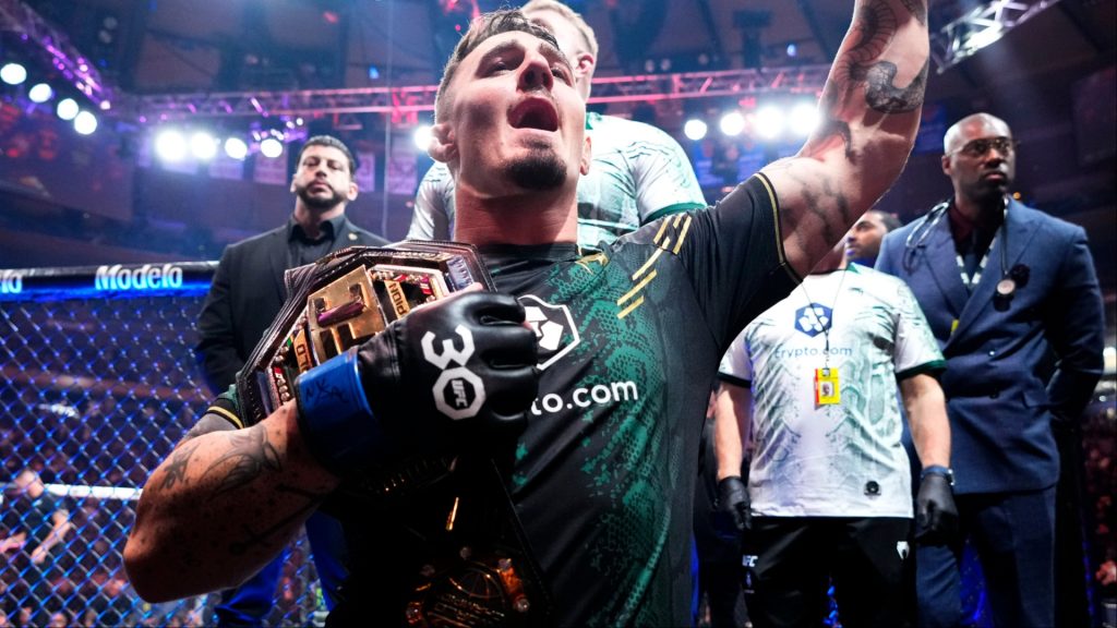 Tom Aspinall celebrates after winning the UFC interim heavyweight title at UFC 295