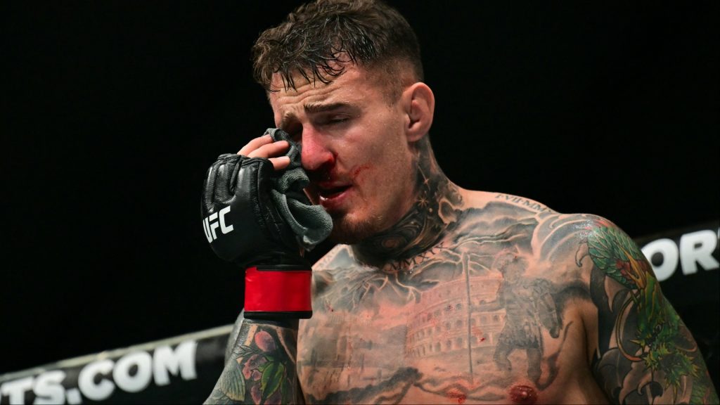 Tom Aspinall reacts after getting poked in the eyes during his fight at UFC 321