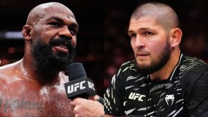 Jon Jones is interviewed after his win at UFC 309, opposite Khabib Nurmagomedov in the corner at UFC 322