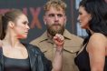 Ronda Rousey and Gina Carano facing off in front of Jake Paul