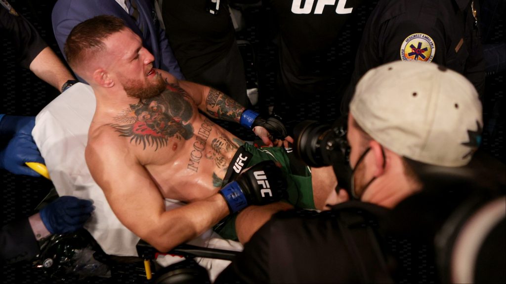 Conor McGregor is escorted from T-Mobile Arena at UFC 264